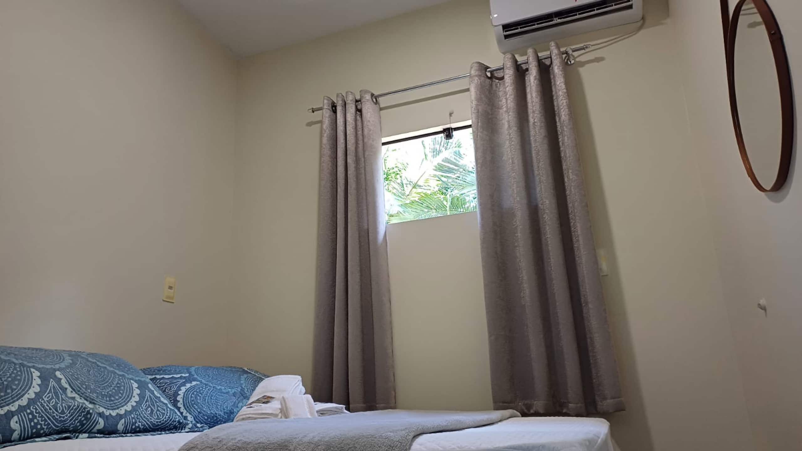 Quarto com cama de casal e janela ampla no Espaço Família